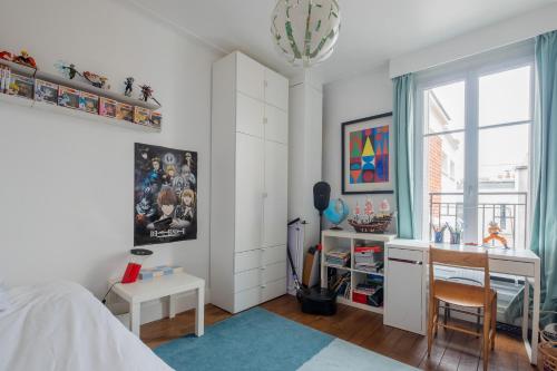 une chambre avec un lit, un bureau et une fenêtre dans l'établissement Veeve - Montmartre Majestique, à Paris