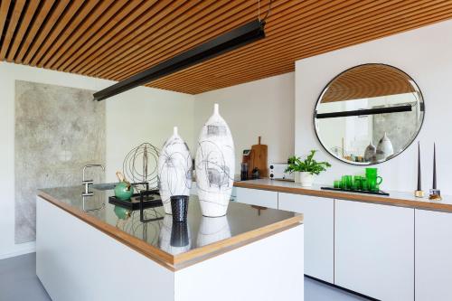 a kitchen with a counter with a mirror and a sink at Veeve - Brazilian Trailblazer in London