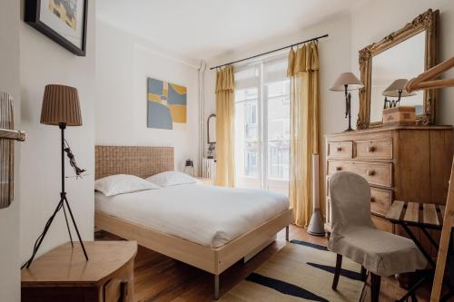 une chambre avec un lit, un bureau et une chaise dans l'établissement Veeve - La Vie Est Belle, à Paris
