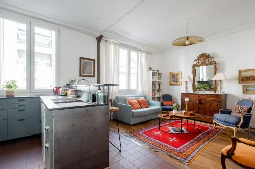 une cuisine et un salon avec un canapé et une table dans l'établissement Veeve - Eminent Grace, à Paris