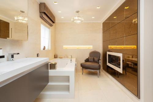 ein Badezimmer mit einem Waschbecken und einem Stuhl in der Unterkunft Veeve - Lavish and Luxe in London
