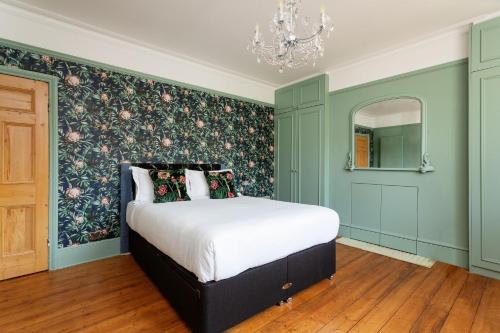 a bedroom with a bed with a floral accent wall at Veeve - Parkland Perfection in London
