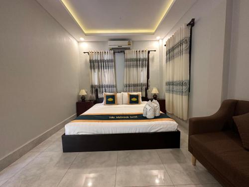 a bedroom with a large bed and a couch at Villa Mahasok hotel in Luang Prabang