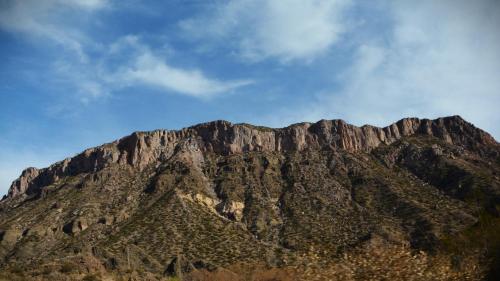 a rocky mountain with a blue sky in the background at Carü Leufu in Valle Grande