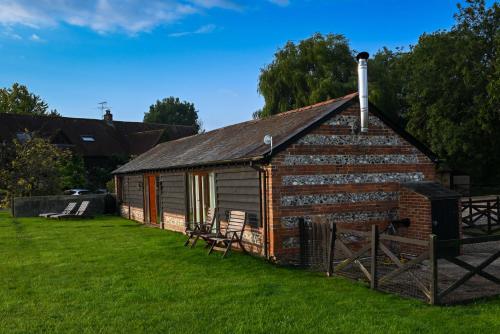 a small brick building with a grass yard at The Tool Shed in Wimborne Minster