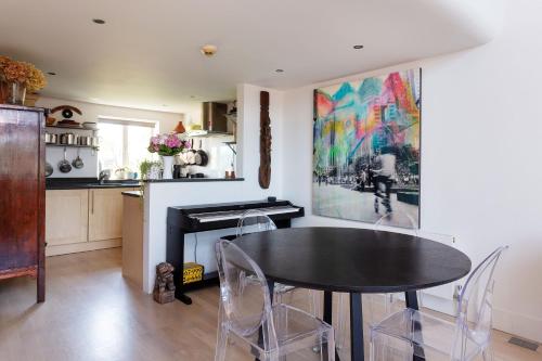 a dining room with a table and a kitchen at Veeve - Celestial Loft in London