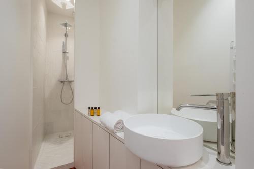 une salle de bain blanche avec toilettes et douche dans l'établissement Veeve - White Beauty, à Paris