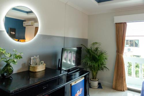 uma sala de estar com televisão e espelho em BH Baan Paradise Hotel em Patong Beach