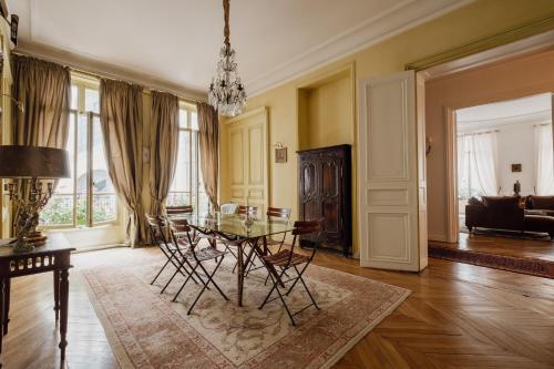 uma sala de jantar com uma mesa de vidro e cadeiras em Veeve - Palatial Grandeur em Paris