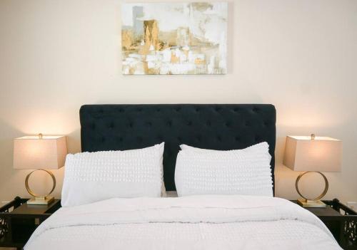 a bedroom with a large bed with two lamps at Exquisite E Charlotte house in Charlotte