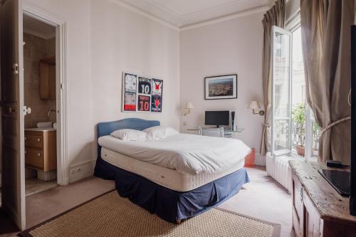um quarto com uma cama grande e uma janela em Veeve - Palatial Grandeur em Paris