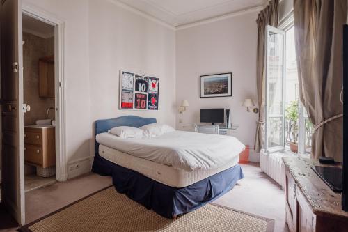 une chambre avec un grand lit et une fenêtre dans l'établissement Veeve - Gilded Dreams, à Paris