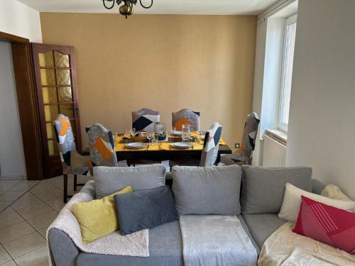 una sala de estar con un sofá y una mesa en Le petit coin des oliviers, en Colmar