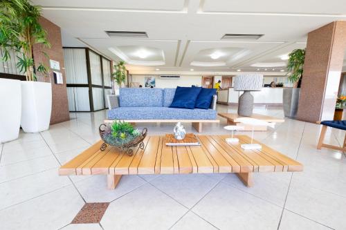 uma sala de estar com um sofá azul e uma mesa em Hotel Verdemar em Salvador