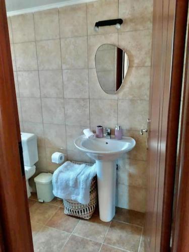 a bathroom with a sink and a mirror and a toilet at Cliffside Cozy Villa w/ Seaviews in Mézapos