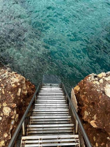 a stairway leading into the water near the ocean at Cliffside Cozy Villa w/ Seaviews in Mézapos