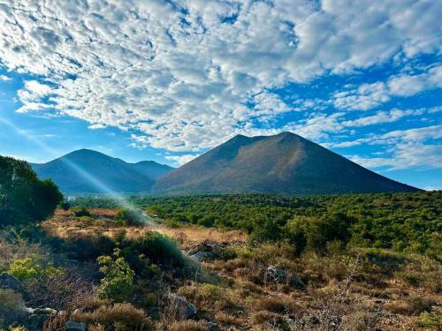 a mountain in the middle of a field at Cliffside Cozy Villa w/ Seaviews in Mézapos