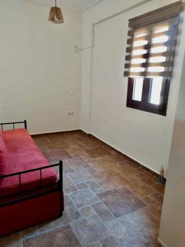 a bedroom with a red bed and a tile floor at Cliffside Cozy Villa w/ Seaviews in Mézapos