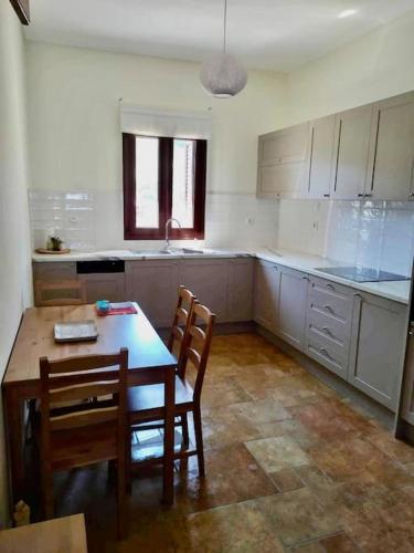 a kitchen with a wooden table and two chairs and a table and a table at Cliffside Cozy Villa w/ Seaviews in Mézapos