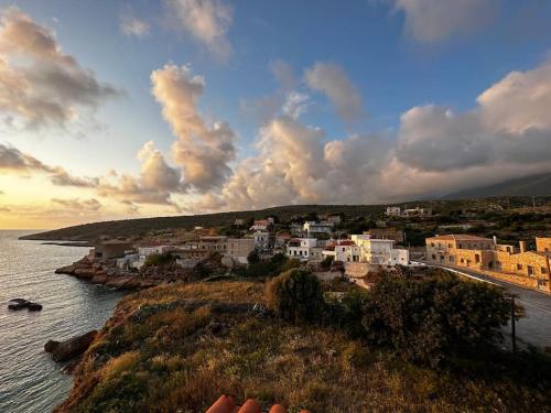 a group of buildings on a hill next to the water at Cliffside Cozy Villa w/ Seaviews in Mézapos