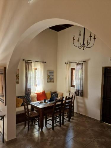 a dining room with a table and chairs and a couch at Villa Penelope Luxury Retreat with Pool & Timeless Charm in Douliana