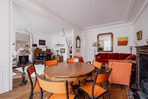 un salon avec une table et un canapé rouge dans l'établissement Veeve - Mid-century Mystique, à Paris