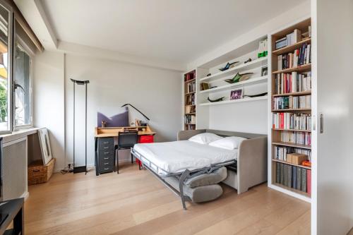 - une chambre avec un lit, un bureau et des étagères dans l'établissement Veeve - Contemporary Heights, à Neuilly-sur-Seine
