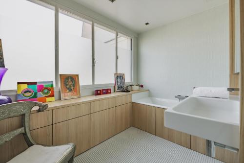 une salle de bain avec un lavabo blanc et une fenêtre dans l'établissement Veeve - Contemporary Heights, à Neuilly-sur-Seine