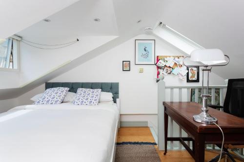 a bedroom with a bed and a desk with a lamp at Veeve - Harmonious Hideaway in London