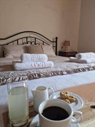 a bed with towels and a cup of coffee and a plate of food at Villa Penelope Luxury Retreat with Pool & Timeless Charm in Douliana