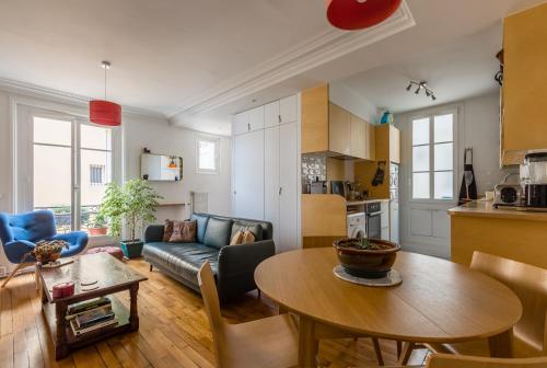 Il comprend une cuisine et un salon avec une table. dans l'établissement Veeve - A la mode in Batignolles, à Paris