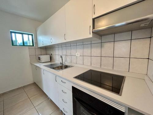 a white kitchen with a sink and a microwave at CASA LALA by Liamar in Playa Honda