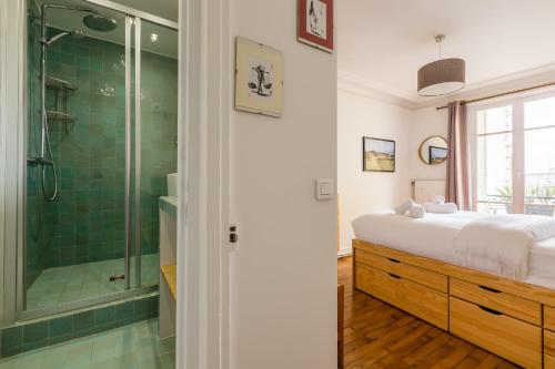 La salle de bains est pourvue d'un lit et d'une douche en verre. dans l'établissement Veeve - A la mode in Batignolles, à Paris