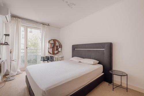 een slaapkamer met een groot bed en een raam bij Veeve - Belle Blanche in Parijs