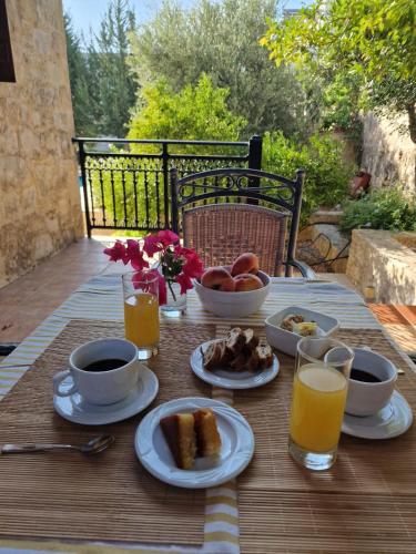 a wooden table with breakfast foods and drinks on it at Villa Penelope Luxury Retreat with Pool & Timeless Charm in Douliana