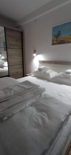 a bedroom with two white beds and a painting on the wall at Planinska idila in Kopaonik