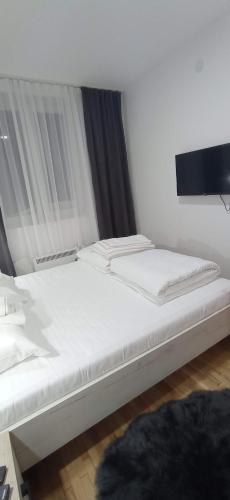 a bedroom with two beds with white sheets at Planinska idila in Kopaonik