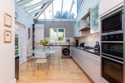 a kitchen with a table and a glass ceiling at Veeve - Blissful Oasis in London