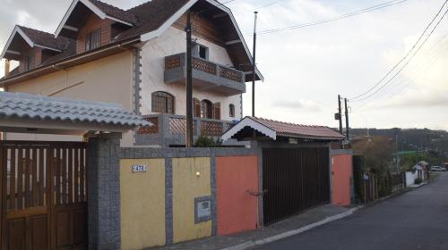 una casa con una puerta y una valla en Cantinho da Bisa, en Campos do Jordão