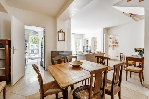 une cuisine et une salle à manger avec une table et des chaises en bois dans l'établissement Veeve - Gilded Garden Splendour, à Paris