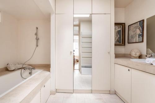 une salle de bain avec une douche, une baignoire et un lavabo dans l'établissement Veeve - Gilded Garden Splendour, à Paris