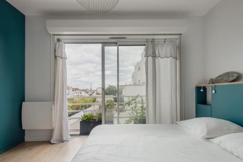 une chambre avec un lit et une grande fenêtre dans l'établissement Veeve - Eyes Towards the Eiffel, à Boulogne-Billancourt