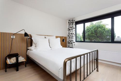 um quarto com uma cama e uma grande janela em Veeve - Visual Virtuosity em Londres
