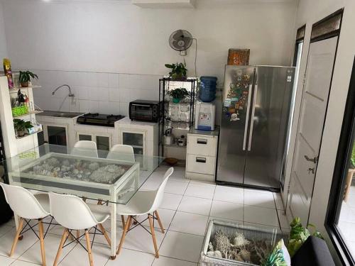 a kitchen with a table and chairs and a refrigerator at Coral House - Near Univ Indonesia Setu Babakan in Jakarta