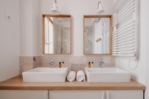 2 lavabos blancos en un baño con 2 espejos en Veeve - Heavenly Elegance en París