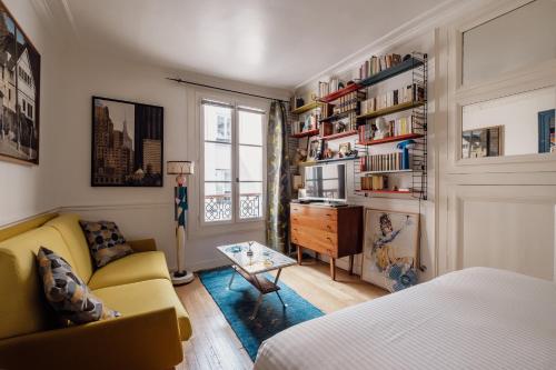 ein Wohnzimmer mit einem gelben Sofa und einem Tisch in der Unterkunft Veeve - Eclectic Eminence in Paris