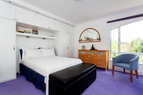 a bedroom with a bed and a chair and a window at Veeve - Canalside Comfort in London