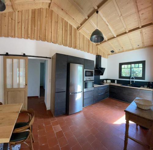een keuken met een roestvrijstalen koelkast en een tafel bij Maison La Plage 26 in Gujan-Mestras