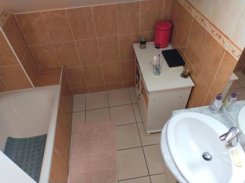 a bathroom with a sink and a toilet and a tub at Maison lotissement du Bérard in Faucon-de-Barcelonnette