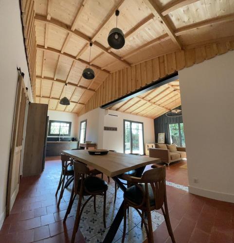 une salle à manger avec une table et des chaises en bois dans l'établissement Maison La Plage 26, à Gujan-Mestras